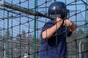 A young batter in the cage