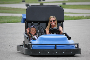 A child waving from a Kart Kountry go-kart